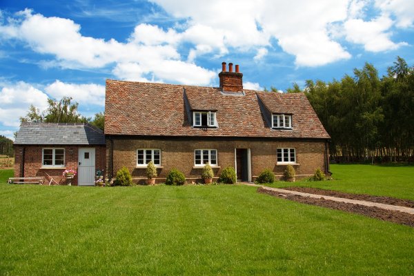 a front view of an older house with a lawn that might need some work